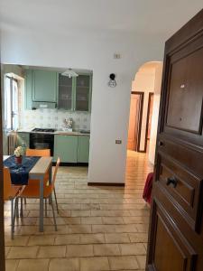 a kitchen with green cabinets and a table and chairs at Casa vacanza Emily in Pedaso