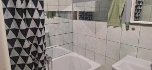 a bathroom with a bath tub and a sink at Kawalerka in Kwidzyn