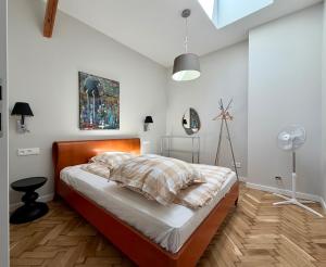 a bedroom with a bed and a lamp and a fan at Apartamenty Stara Winiarnia in Wałcz