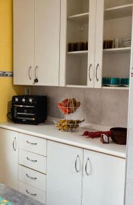 a kitchen counter with white cabinets and a microwave at Recanto D'Carvalho in Passa Quatro