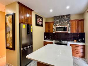 a kitchen with a stainless steel refrigerator and wooden cabinets at Hosteria Arizona in Puyo