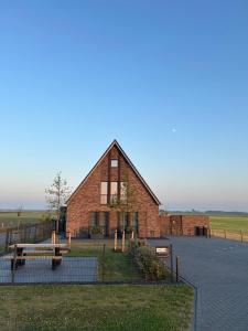 a brick building with a bench in front of it at Afslag 5 Texel Bed by Brandenburg in Den Burg +23 photos