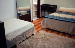 a bedroom with two twin beds and a mirror at Recanto D'Carvalho in Passa Quatro