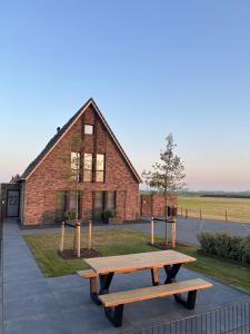 a picnic table in front of a brick building at Afslag 5 Texel Bed by Brandenburg in Den Burg