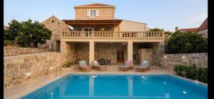 a villa with a swimming pool and a house at Villa Bellezza in Čilipi