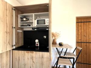 a small kitchen with a microwave and a table at Studio cosy avec balnéo et climatisation in Albi