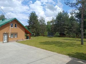 a house with a grassy yard next to a building at Planinska Kuća Nišićka visoravan in Ilijaš