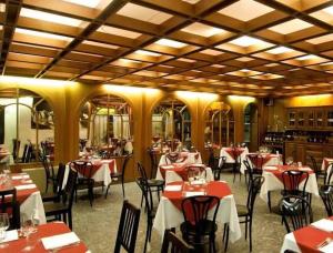 a restaurant with red tables and chairs in a room at Appartamento in Hotel Residence Universo in Pré-Saint-Didier