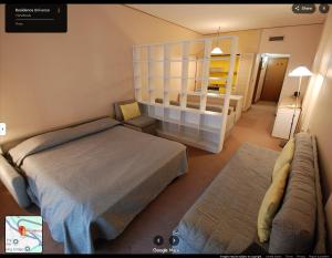 a bedroom with a bed and a couch and a mirror at Appartamento in Hotel Residence Universo in Pré-Saint-Didier