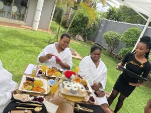 a group of women sitting at a table with food at Mpala Boutique Hotel in Bulawayo