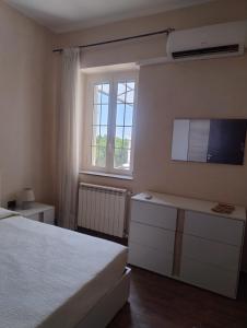 a bedroom with a bed and a tv and a window at B&B Vista Mare in Palmi