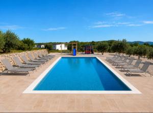 a large swimming pool with chairs and a playground at Luxury mobile home INES in Drage