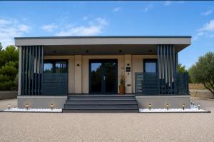 a small building with blue shutters on it at Luxury mobile home INES in Drage