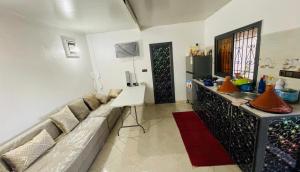 a living room with a couch and a kitchen at Dar Calme Takad in Ben Guemoud