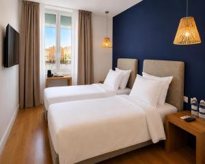 a hotel room with two beds and a window at Hotel De La Mer in Nice +26 photos