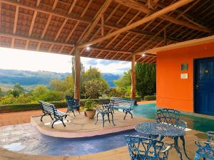 a patio with tables and chairs with a view of the mountains at Pousada Pico do Papagaio in Aiuruoca