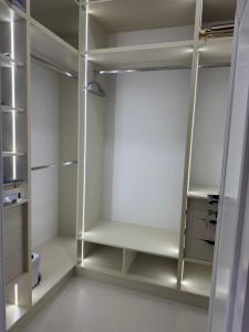 a walk in closet with white walls and shelves at NRG BI Sado in Salor Bekati