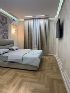 a bedroom with a bed and a flat screen tv at NRG BI Sado in Salor Bekati