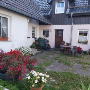 a house with a table and chairs and flowers at Eifelhaus in Hürtgenwald