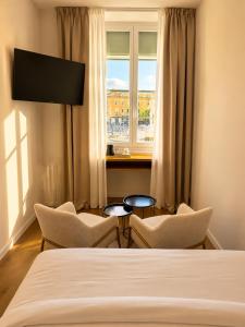 a bedroom with two chairs and a bed and a window at Hotel De La Mer in Nice