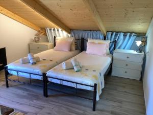two twin beds in a room with wooden ceilings at Zante Villa Amici Loft in Zakynthos +36 photos