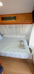 a bed in a room with a wooden cabinet at Ella's Camper in Fontinha +16 photos