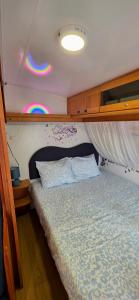 a bedroom with a bed and a ceiling withbows at Ella's Camper in Fontinha