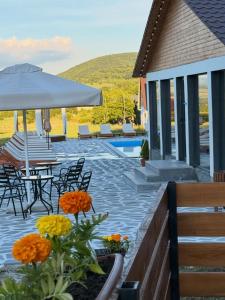 a patio with a table and chairs and a pool at Narnia Cottages in Bazalet'i