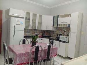 a kitchen with a table with a pink table cloth at Veneza Exclusive 101 in Ipatinga
