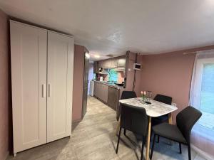 a room with a table and chairs and a kitchen at SeaSoul Cottage in Zvejniekciems