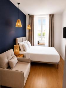a hotel room with two beds and a couch at Hotel De La Mer in Nice