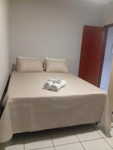 a bed with two towels on top of it at Veneza Exclusive 101 in Ipatinga