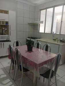 a kitchen with a table with a potted plant on it at Veneza Exclusive 101 in Ipatinga +2 photos