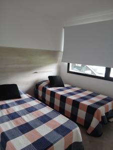 two beds in a room with a window at Luna & Playa in Playa Dorada