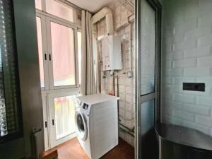 a washing machine in a kitchen with a window at Alma Andaluza Apart 1 in Mairena del Aljarafe
