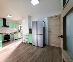 a kitchen with green cabinets and a refrigerator at Alma Andaluza Apart 1 in Mairena del Aljarafe