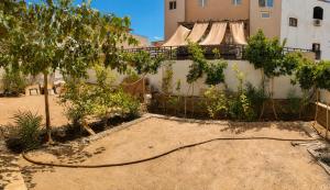 a garden with a hose in front of a building at Tarbouche House Dahab in Dahab