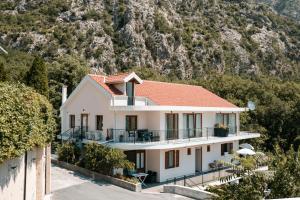 a house with a mountain in the background at Hill House Orahovac in Kotor