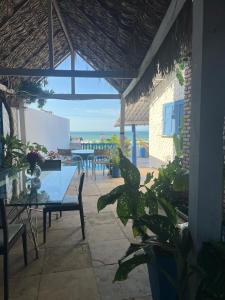 a patio with a table and chairs and the ocean at Vistamar Arco das Flores 2 in Taíba