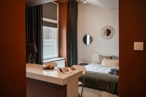 a bedroom with a bed and a table and a mirror at Apartamenty Młyńska15 self check-in 24h in Katowice