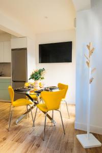 a dining room with yellow chairs and a table at Villa Martena in Cambados