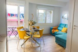 a living room with a table and yellow chairs at Villa Martena in Cambados