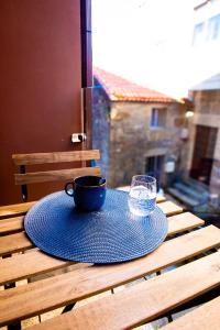 a blue plate with a cup and a glass on a table at Villa Martena in Cambados