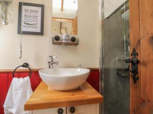 a bathroom with a white bowl sink on a wooden counter at The Journeyman Luxury Shepherds Hut in Barnoldswick +18 photos