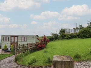 a tiny house on a hill with a yard at The Journeyman Luxury Shepherds Hut in Barnoldswick