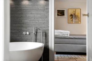 a bathroom with a bath tub and a bed at LF11977-Struer-Norskovvej-17 in Vemb +27 photos