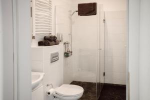 a white bathroom with a toilet and a sink at Apartamenty Młyńska15 self check-in 24h in Katowice +45 photos