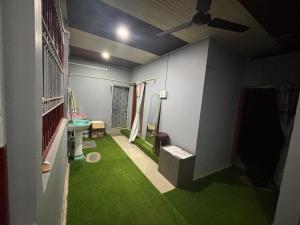 a bathroom with a green floor and a toilet at RADHE RADHE HOMESTAy in Dithur