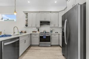 a kitchen with white cabinets and a stainless steel refrigerator at Lavender Life in Saint James City