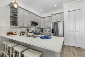 a kitchen with white cabinets and a kitchen island with stools at Lavender Life in Saint James City
